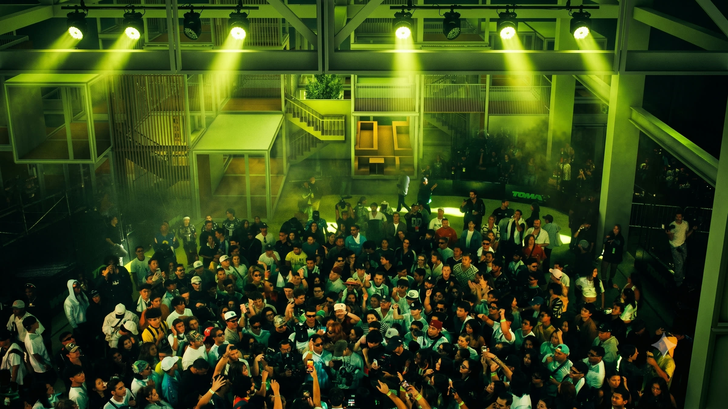 The frame occupied as a performance venue, crowd under stage lighting